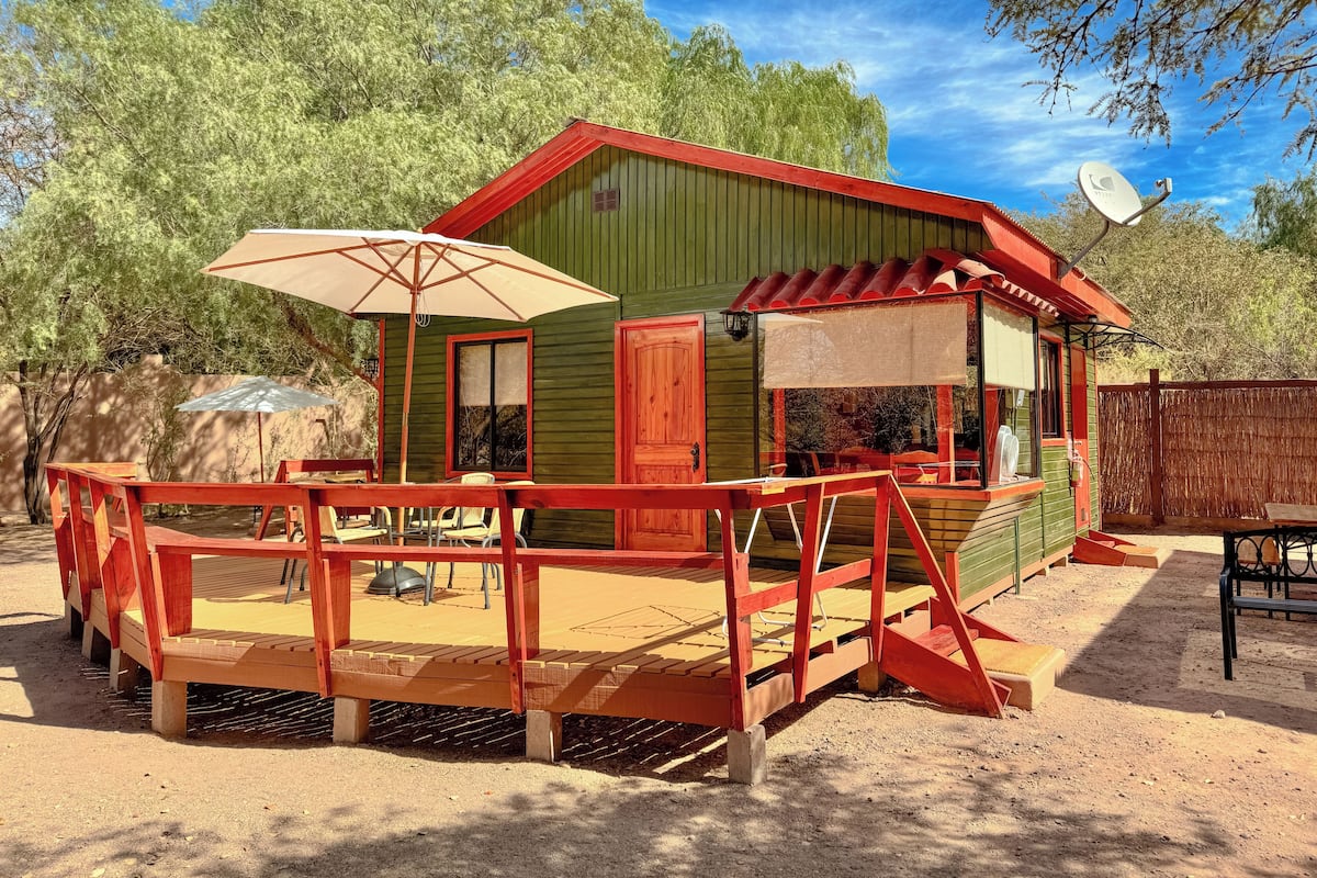 A wooden structure with a red roof and a covered patio area.