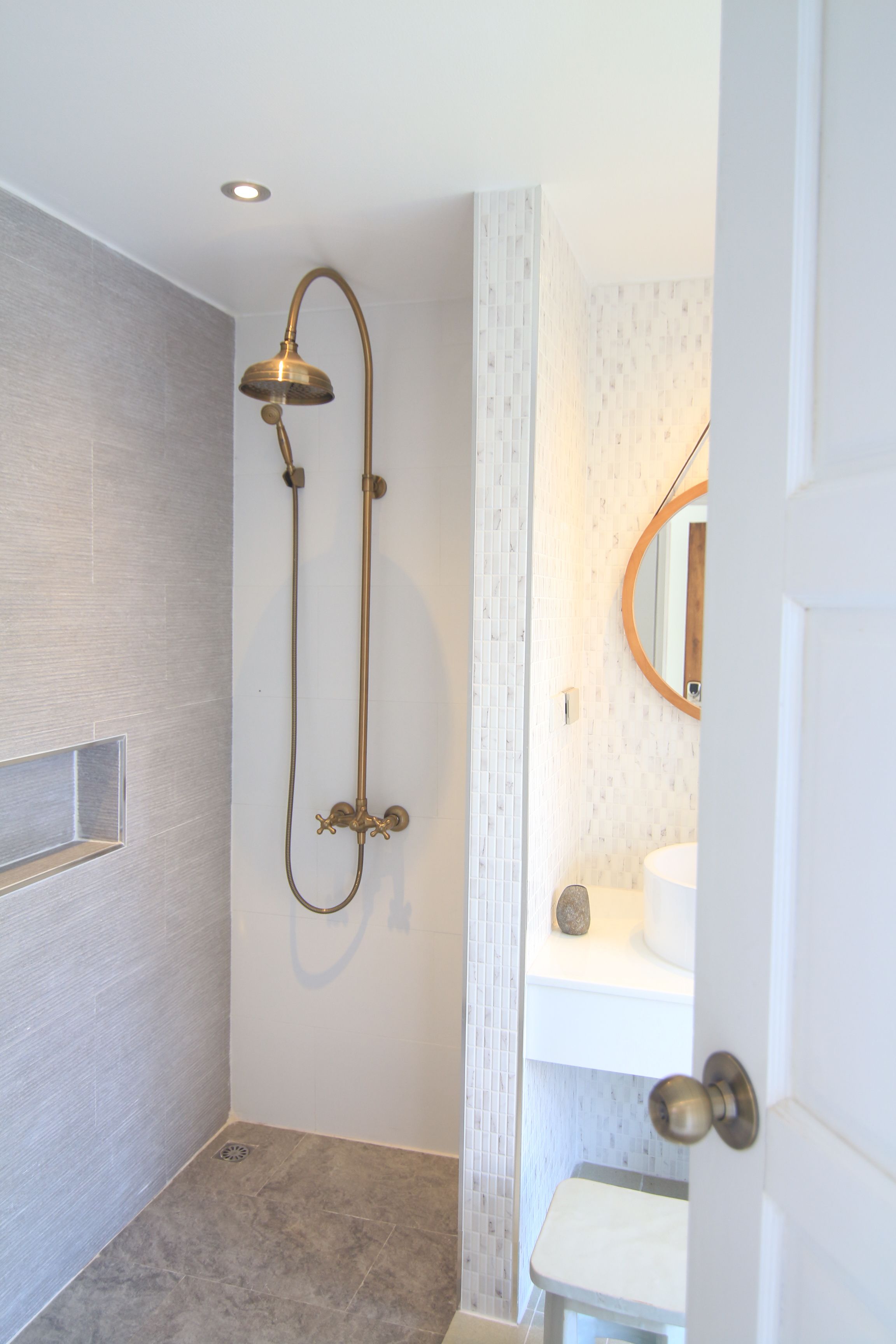 Un baño con ducha, lavabo y espejo.