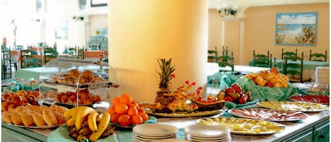 A buffet with various food items and a large pillar in the center.