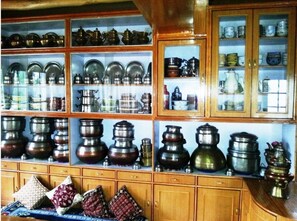 A kitchen with wooden cabinets and glass display shelves filled with various kitchenware.