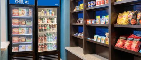 Un área de venta con dos refrigeradores que dicen “CHILL OUT” y un estante lleno de aperitivos y bebidas.