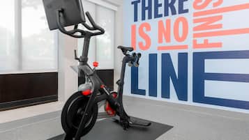 Een overdekte trainingsfiets met een motiverende poster op de achtergrond.