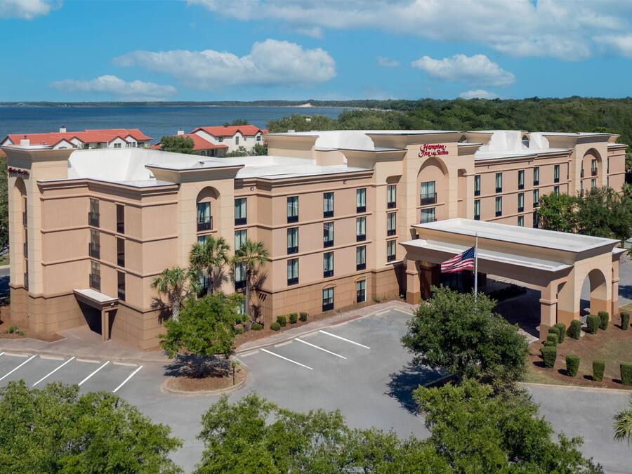 A large hotel with a central courtyard, multiple floors, and a view of the sea.