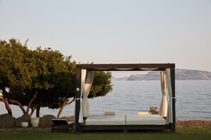 Am Strand, weißer Sandstrand, Liegestühle, Sonnenschirme