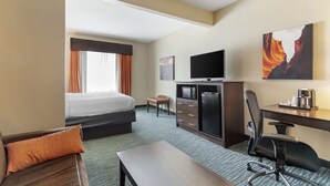 A hotel room with a bed, a desk, a television, and a painting on the wall. - Best Western Plus Longhorn Inn & Suites (Luling)