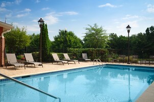 Una piscina al aire libre, sombrillas