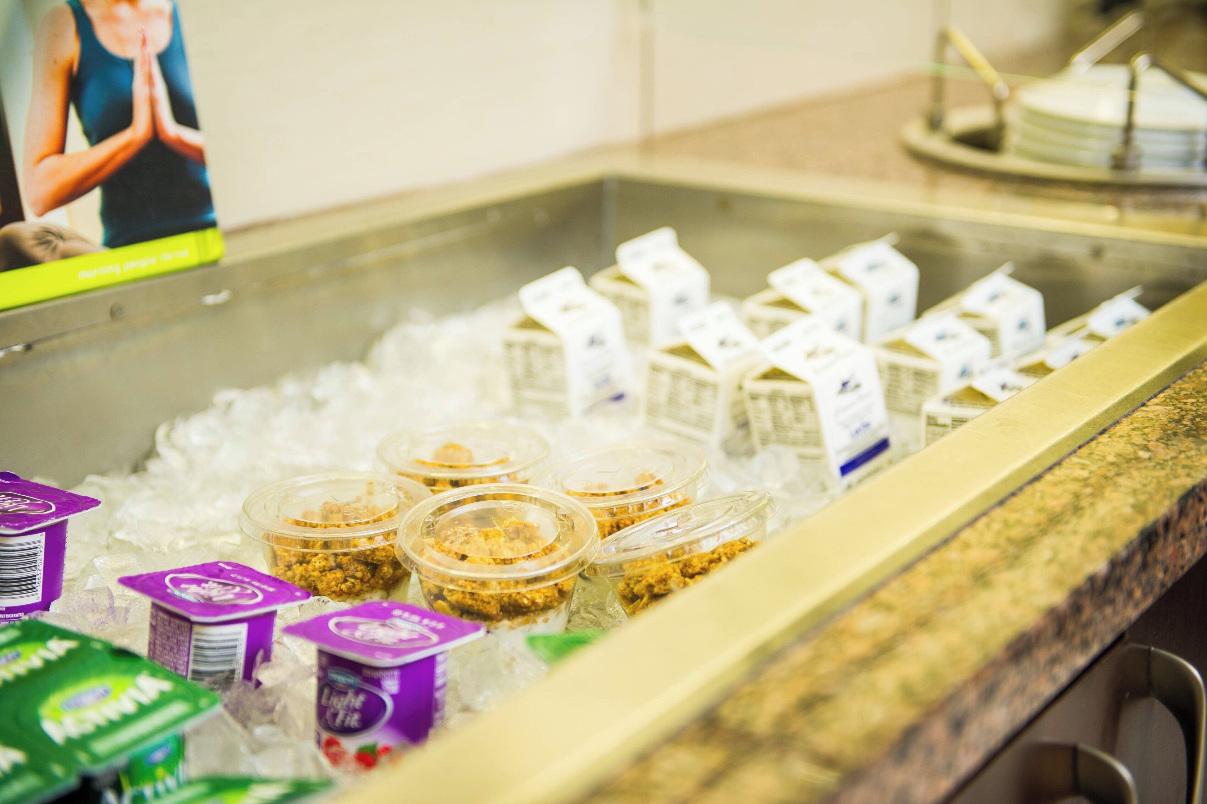 Zona de bufé con diferentes alimentos y recipientes sobre hielo.