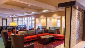 A modern lobby with a sectional sofa, armchairs, a coffee table, and a patterned carpet. - Residence Inn by Marriott Columbia Northwest/Harbison (Irmo)