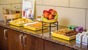 A buffet with various food items including apples, pastries, and cereal boxes. - Residence Inn by Marriott Columbia Northwest/Harbison (Irmo)