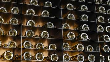 Una pared con numerosos vasos de vino dispuestos en un patrón de cuadrícula.