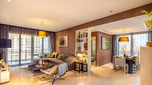 A modern living room with a sofa, coffee table, and dining area.