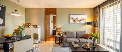 A modern living room with a sofa, coffee table, and a dining area with a table and chairs.