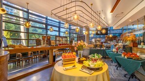 A spacious dining area with high ceilings, large windows, and modern lighting fixtures.