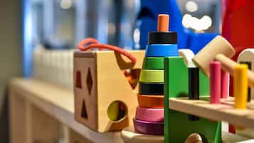 A wooden play structure with colorful blocks and a small house.