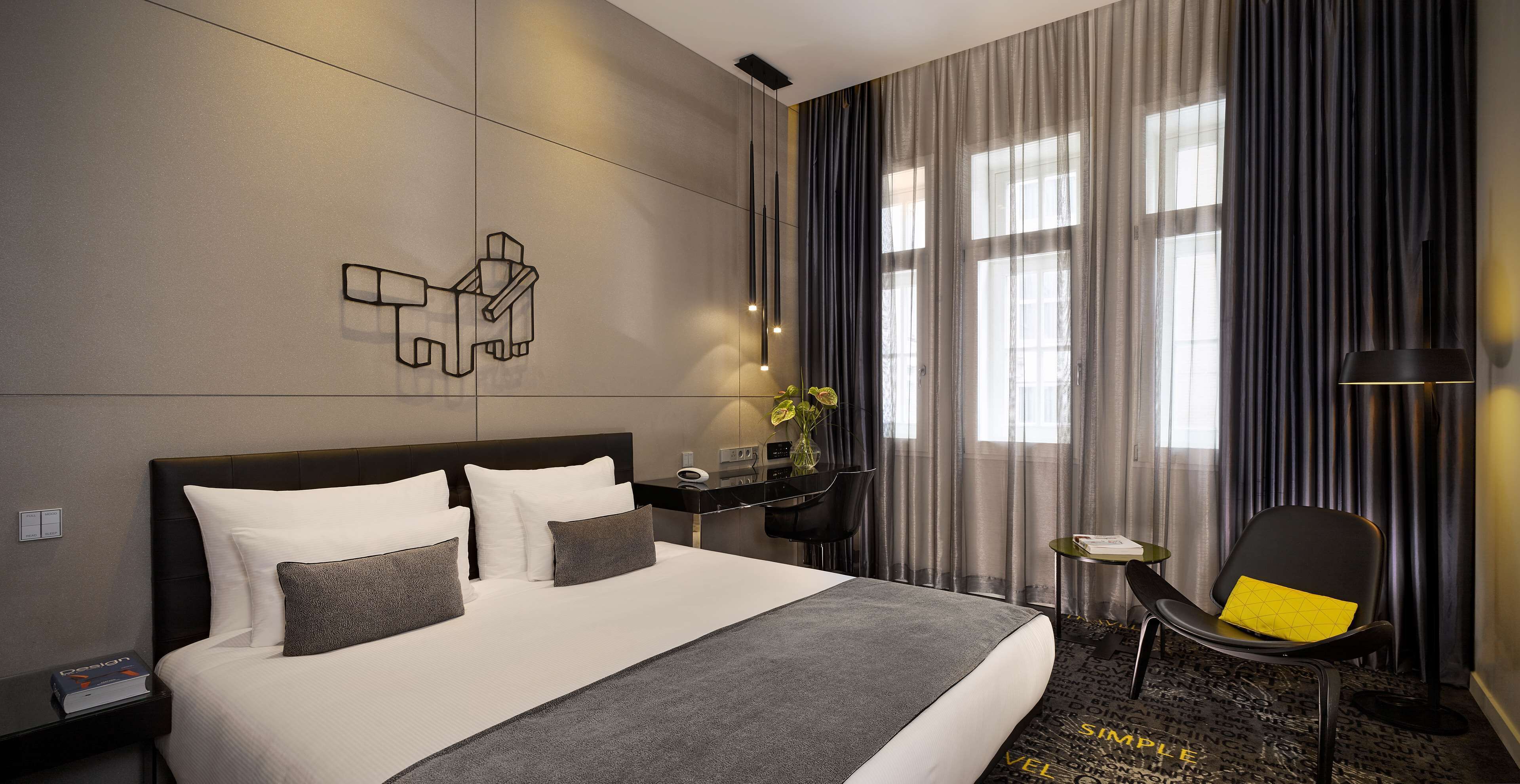 Ein modernes Hotelzimmer mit einem großen Bett, einem Schreibtisch und einem Sessel.