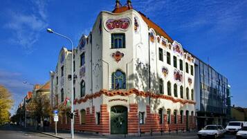 A historic building with a distinctive facade, a prominent entrance, and a modern glass extension.