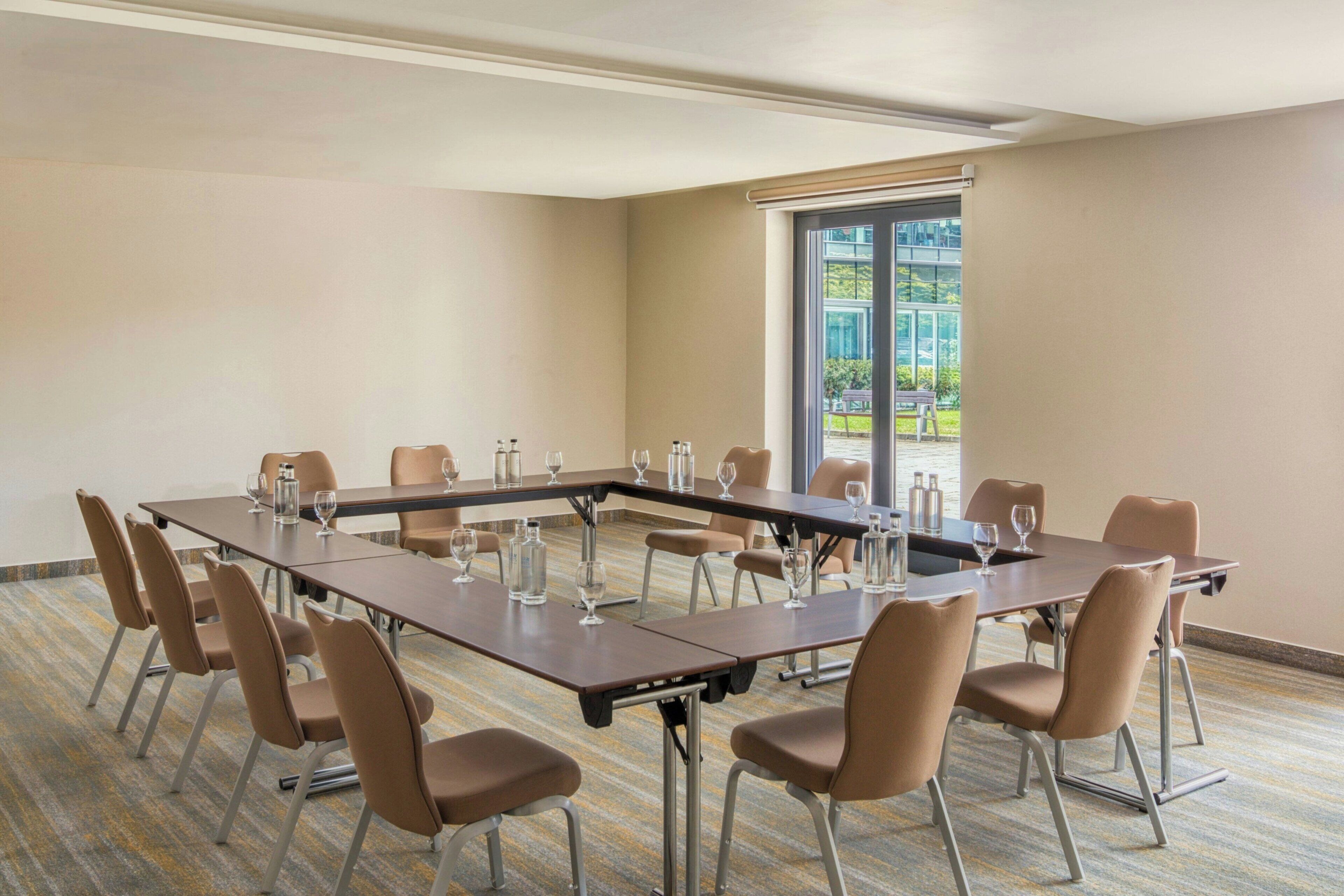 A conference room with a long table, chairs, and a large window.