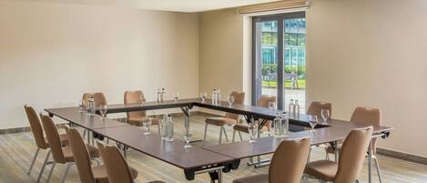 A conference room with a long table, chairs, and a large window.