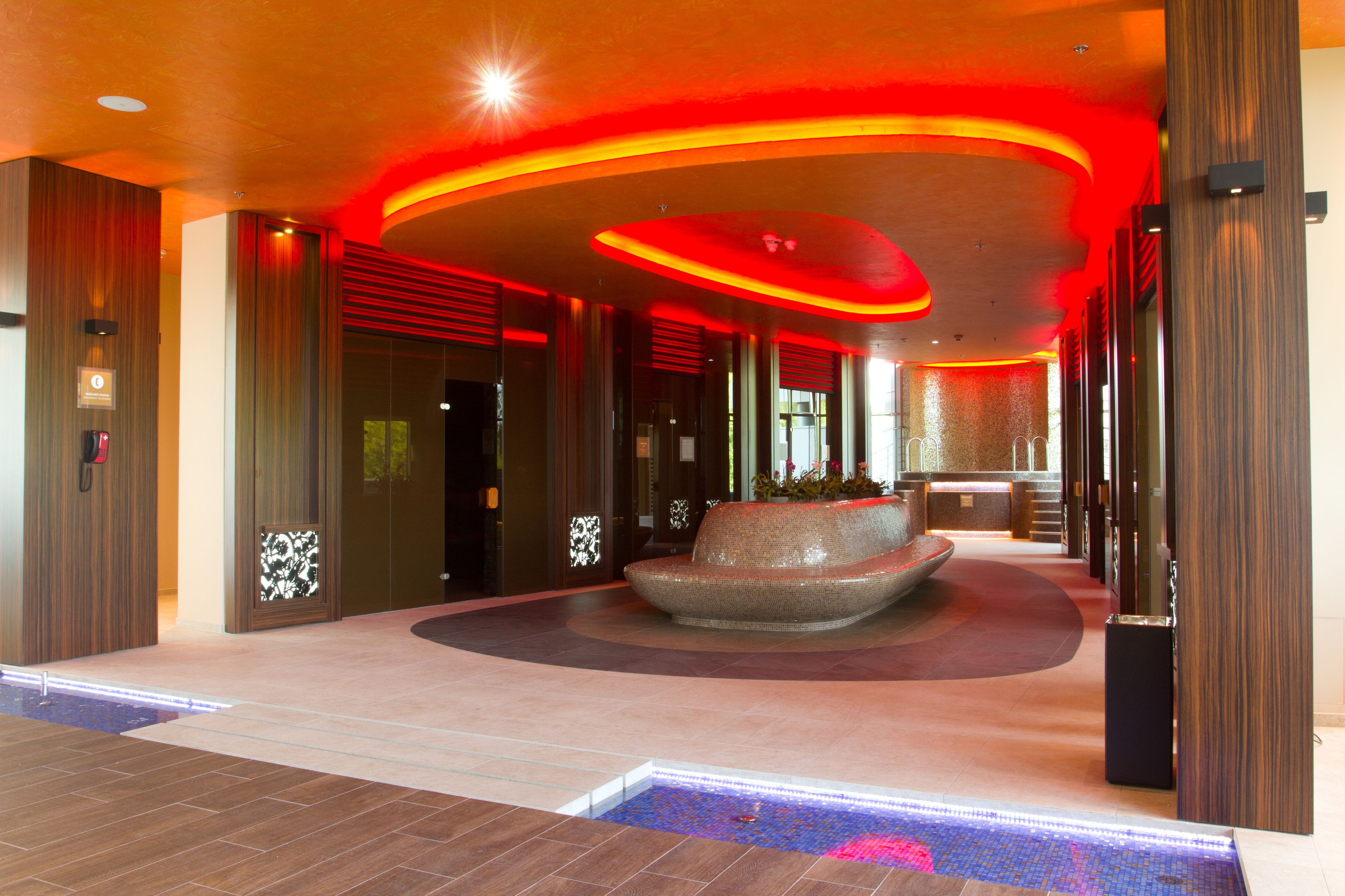 Un vestíbulo moderno con una zona de estar central, un mostrador de recepción y un suelo con diseño.