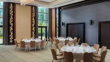 A conference room with round tables, chairs, and a large window.