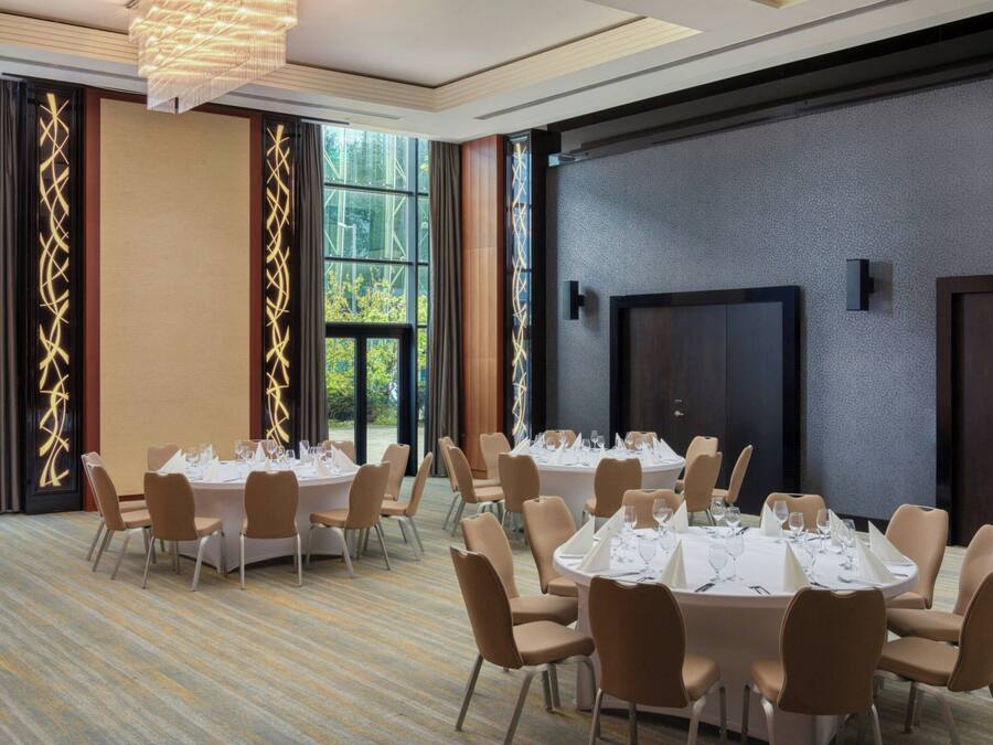 A conference room with round tables, chairs, and a large window.