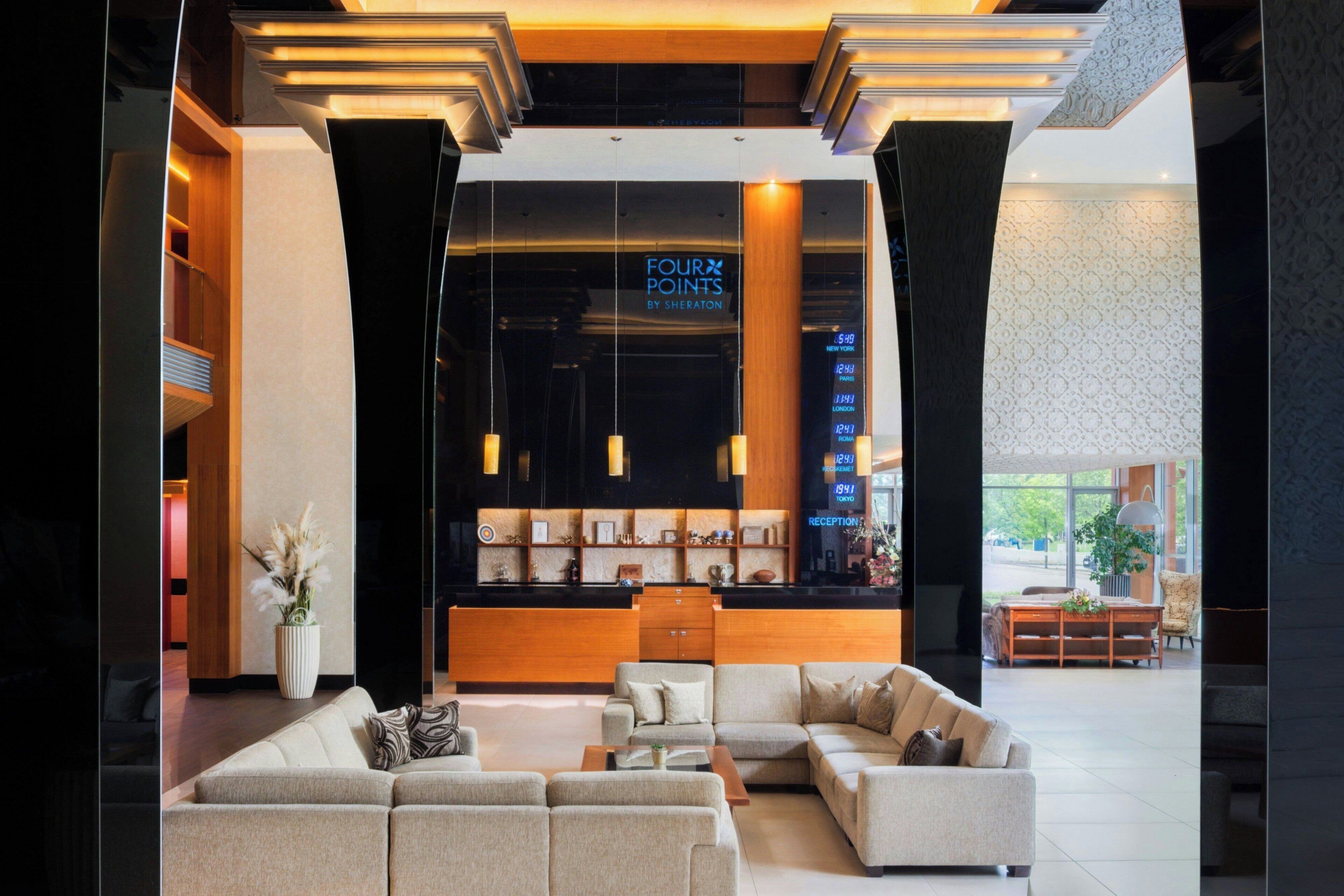 Eine moderne Lobby mit einer Rezeption, Sofas und einem großen Fenster.