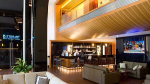 Un espace bar moderne, doté de sièges et d’une enseigne visible indiquant l’emplacement du restaurant.
