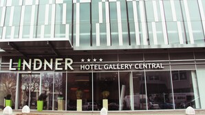 El exterior del Hotel Lindner Gallery Central, con amplios ventanales y una fachada moderna.