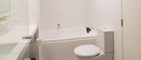 A modern bathroom with a bathtub, toilet, and sink.
