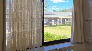 A kitchen with a window, curtains, and a sink.