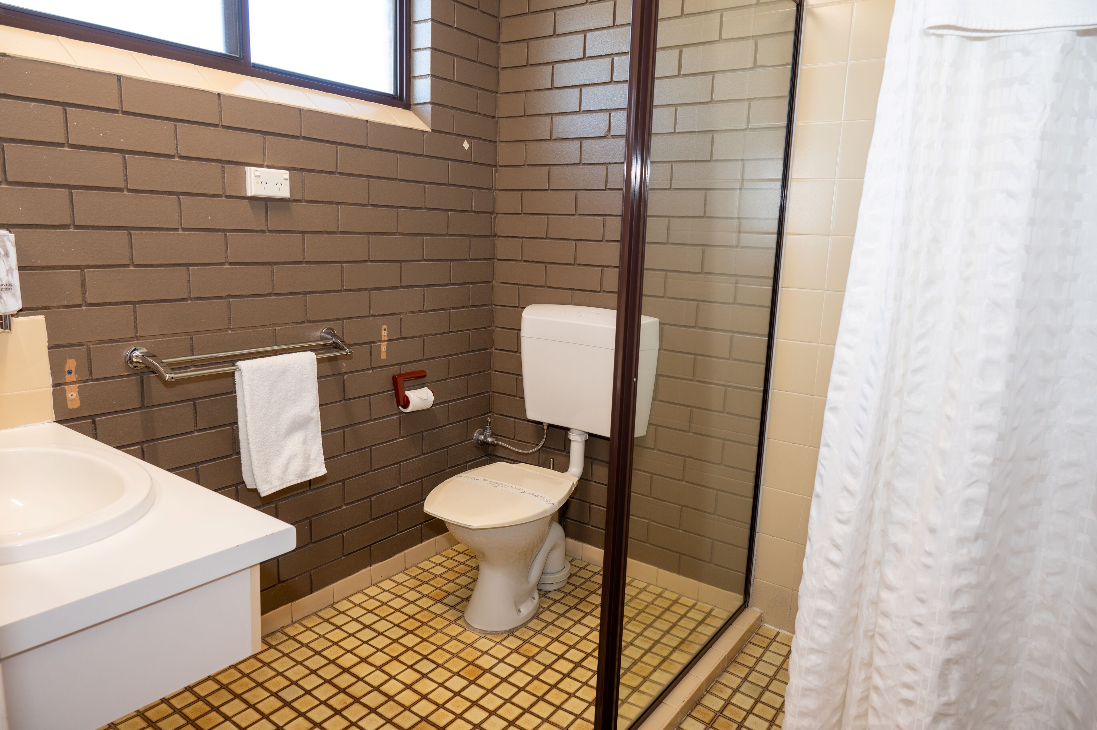Ein Badezimmer mit Toilette, Waschbecken und Dusche.
