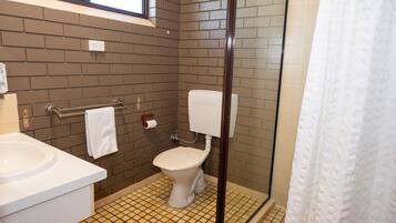 Ein Badezimmer mit Toilette, Waschbecken und Dusche.