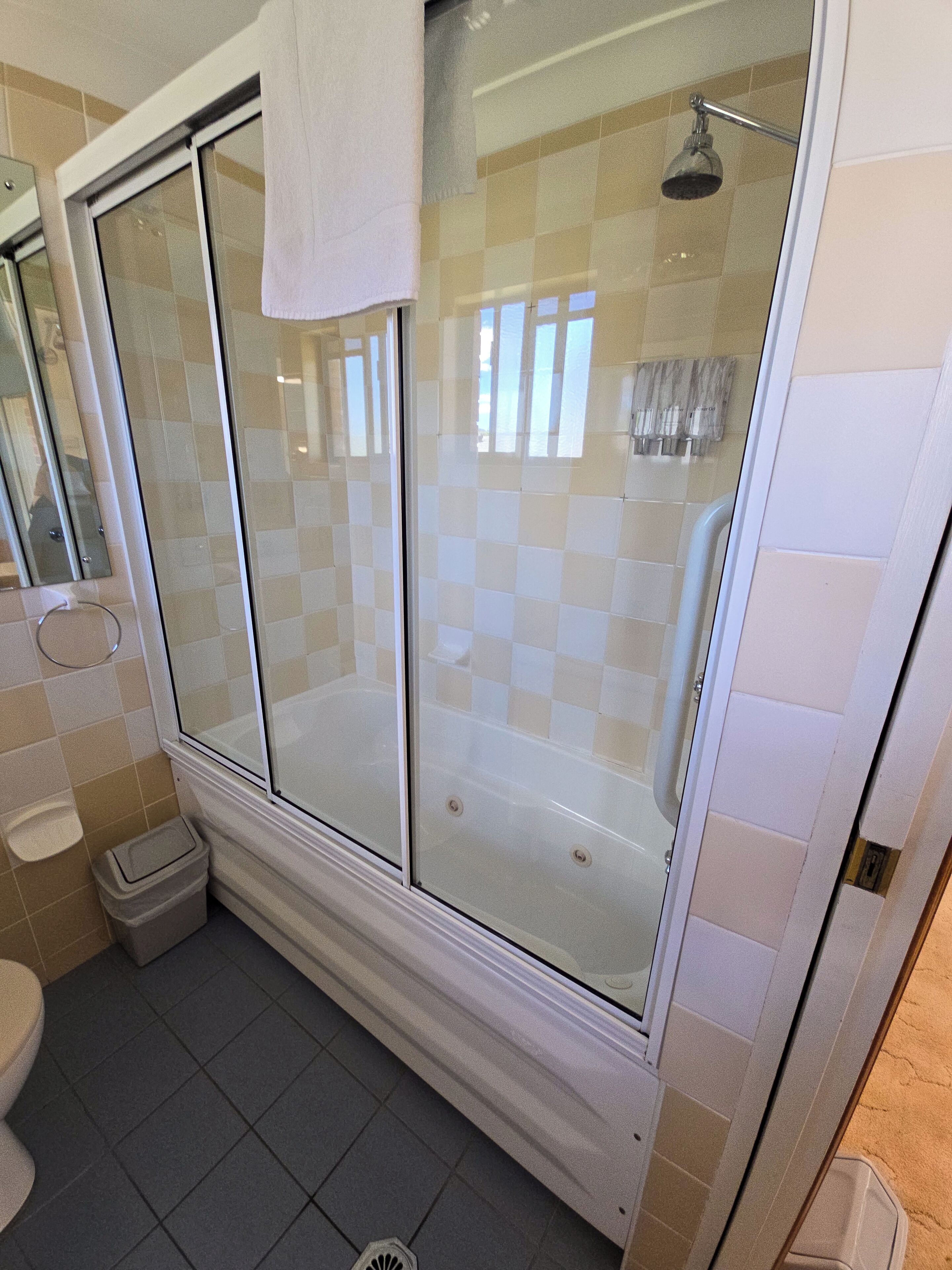 A bathroom with a glass-enclosed shower, a toilet, and a sink.
