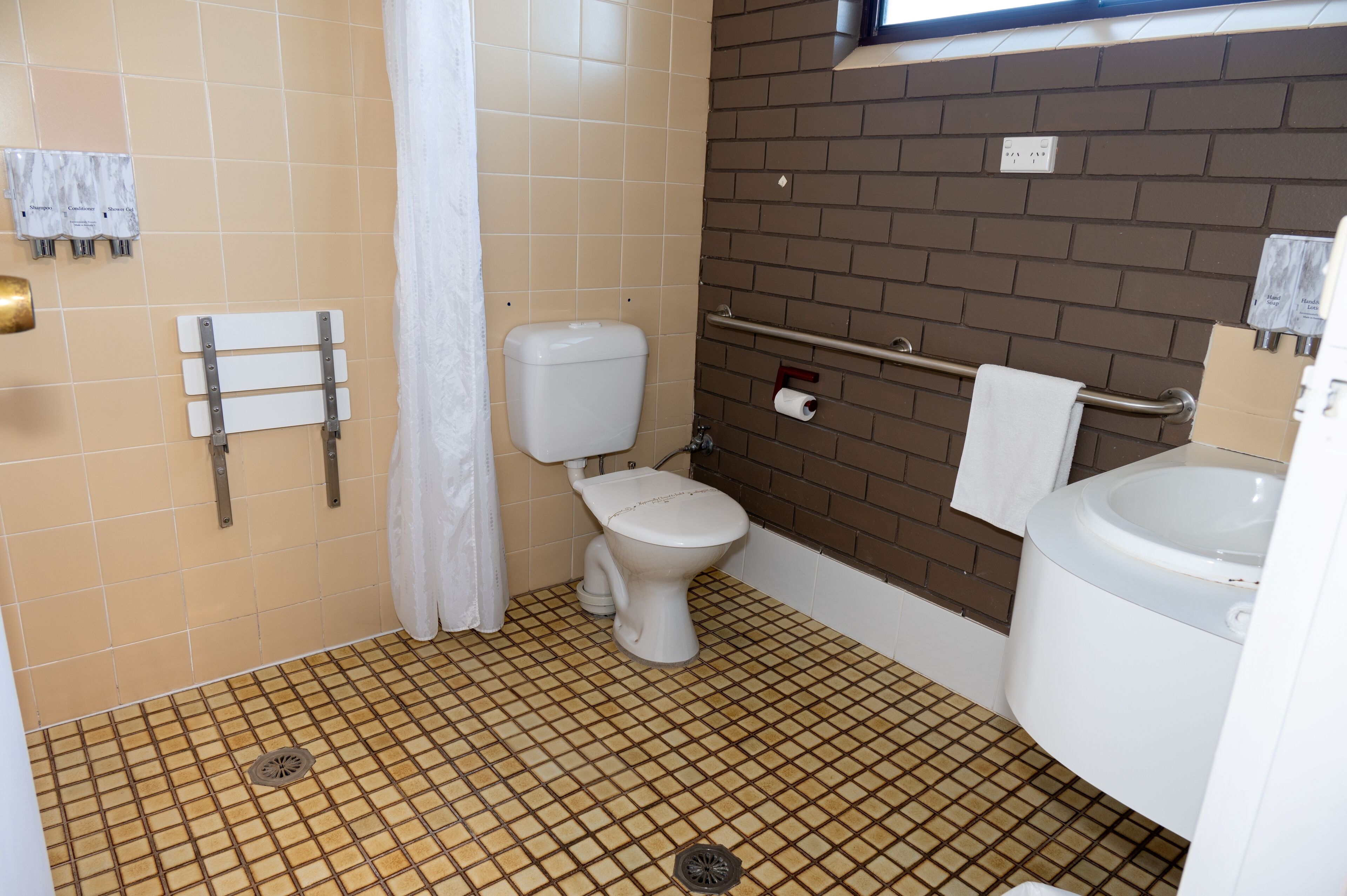 Ein Badezimmer mit Toilette, Waschbecken und Duschbereich.