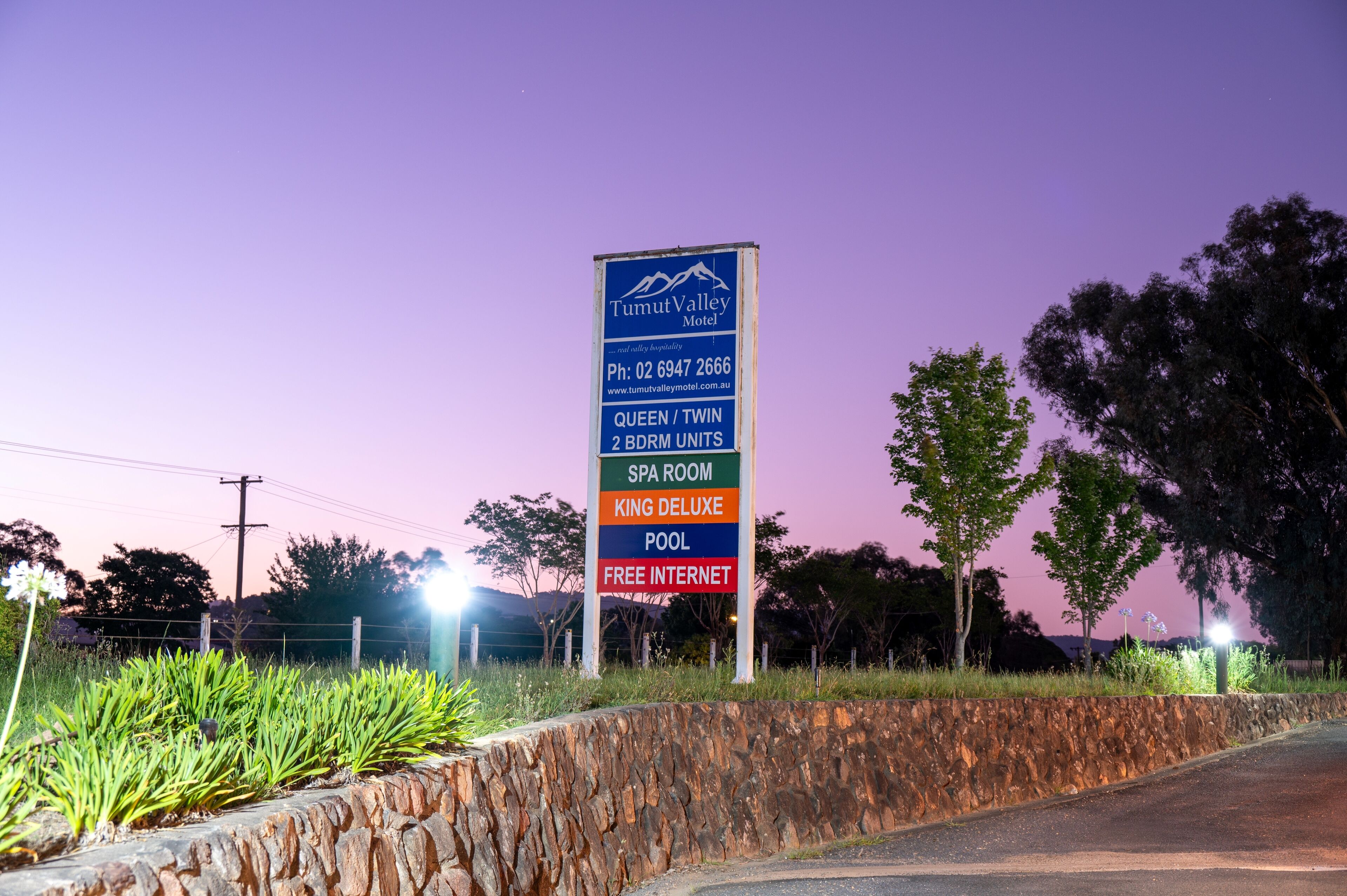 A sign for Tumut Valley Motel advertising amenities such as queen/twin beds, 2 BDRM units, a spa room, king deluxe pool, and free internet.