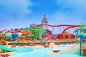 Een waterpark met meerdere glijbanen en zwembaden, een toren en zitgedeeltes.