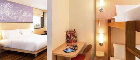 Une chambre d’hôtel comprenant un lit, un bureau avec une chaise, une petite table avec une chaise et un lit superposé.