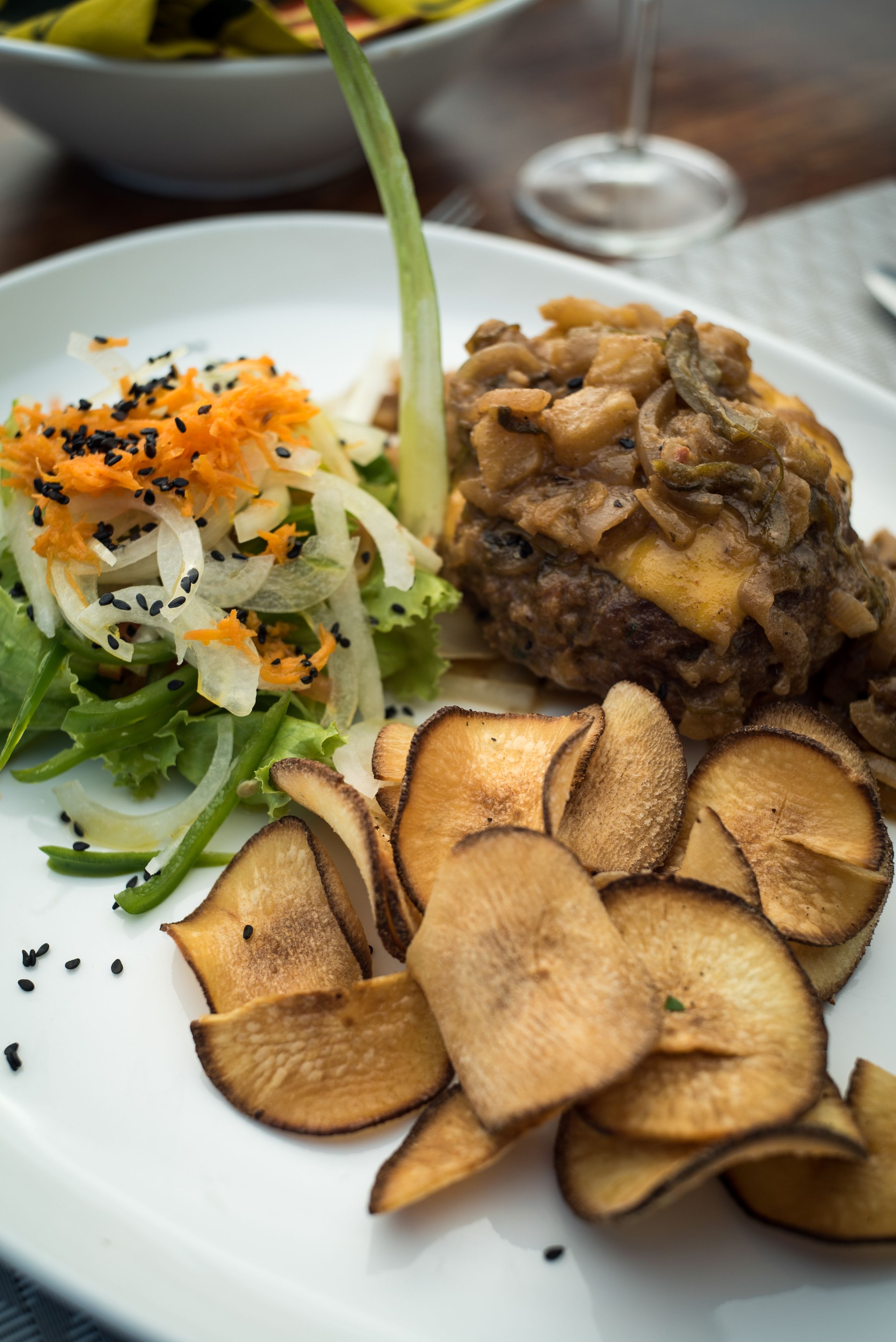 A plate with a salad, mushrooms, and chips.