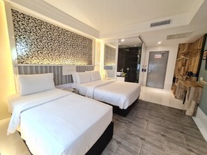 A modern hotel room with two beds, a shower area, and a wooden shelf with a kettle.