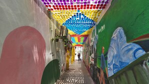 A narrow corridor with colorful ceiling decorations and murals on the walls. - Arenaa Star (Kuala Lumpur)