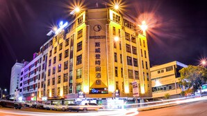 Hotel Boutique Sherinton con un letrero destacado, varios pisos y una fachada bien iluminada.