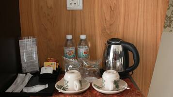 Preparación para el desayuno en una habitación de hotel, con una bandeja, dos tazas, dos botellas de agua, un hervidor y un menú.