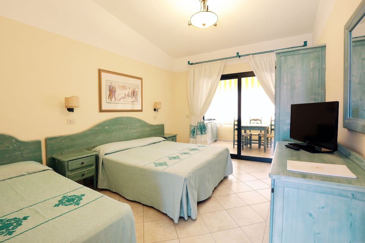 Une chambre d’hôtel avec deux lits, une télévision, un bureau et une chaise.