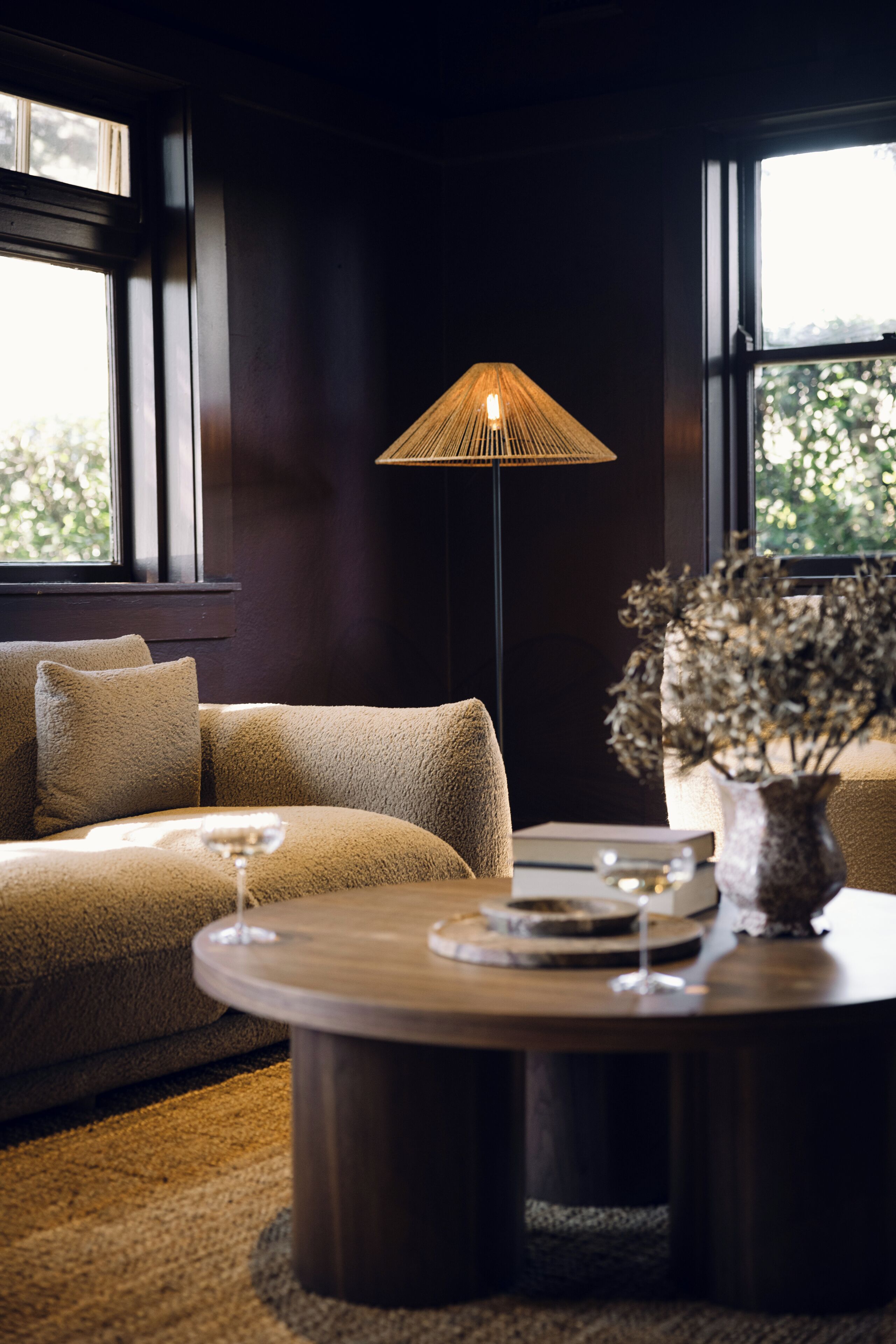 A cozy living room with a sofa, a round coffee table, and a floor lamp.