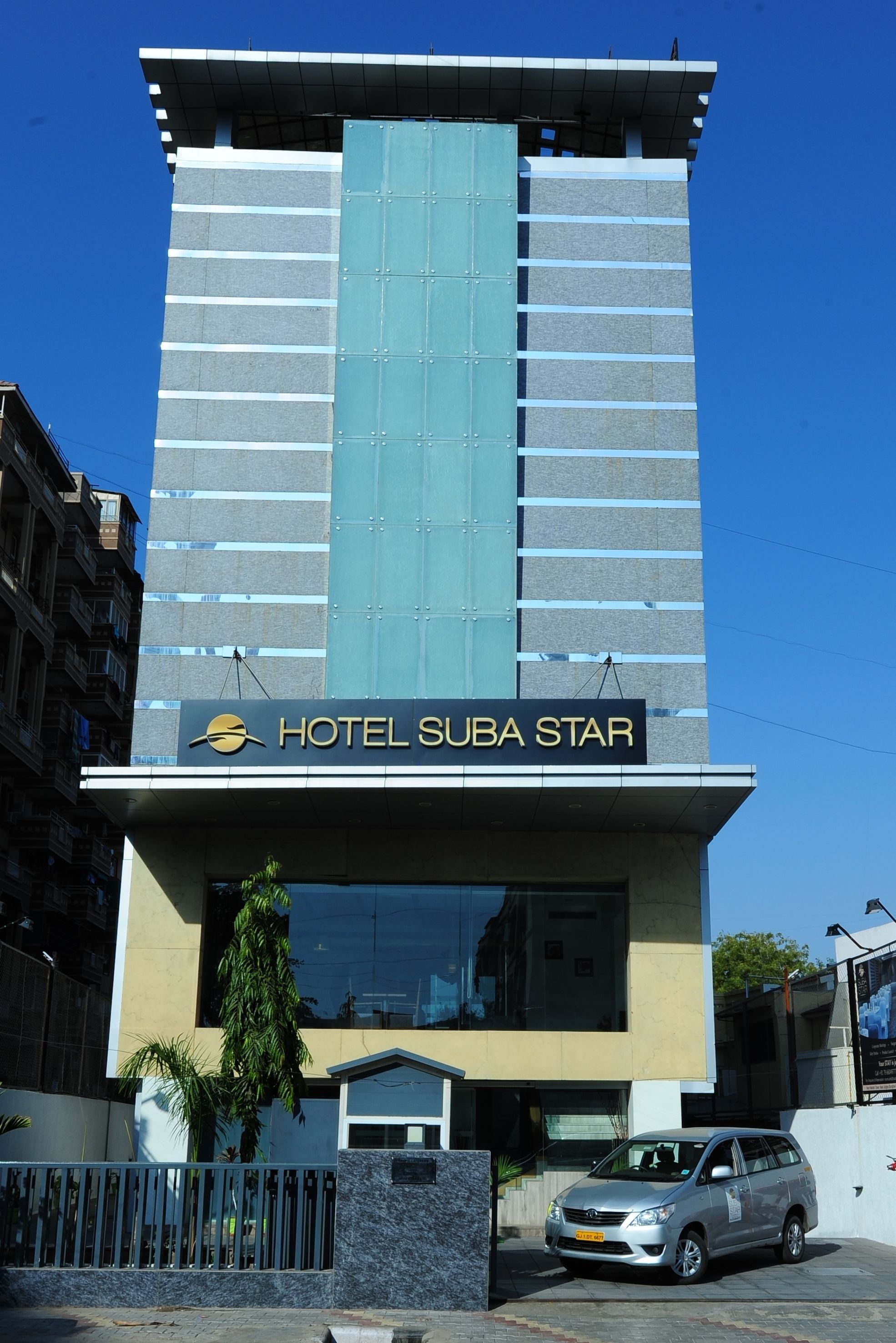 Un bâtiment moderne avec une enseigne indiquant « HÔTEL SUBA STAR ».