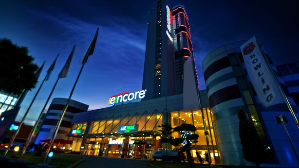 A hotel with a prominent 'Encore' sign, a modern architectural design, and a well-lit entrance area.