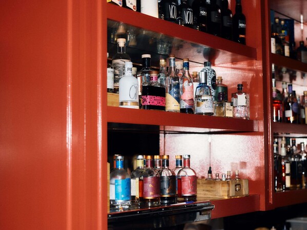 A bar with shelves of various liquor bottles. - Hotel Woolstore 1888, Sydney - Handwritten Collection (Pyrmont)