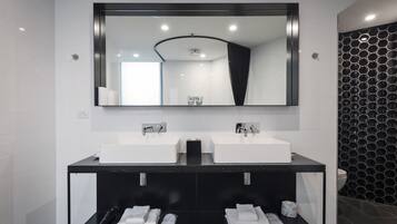 Un baño moderno con dos lavamanos, un espejo grande y un mueble de tocador negro.