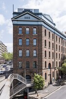 Un edificio histórico con el año 1888 exhibido en la fachada, con revestimiento de ladrillo y múltiples ventanas.