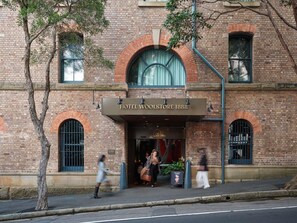 A historic hotel with a brick facade, arched windows, and a prominent entrance sign. - Hotel Woolstore 1888, Sydney - Handwritten Collection (Pyrmont)